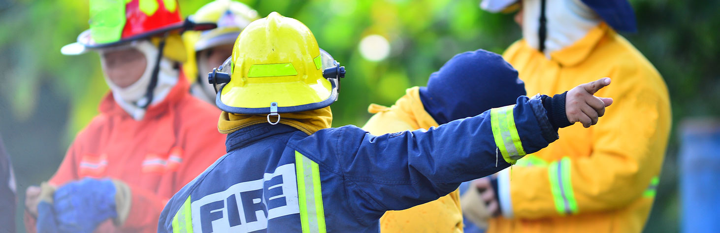 A firefighter in a blue jacketing pointing right
